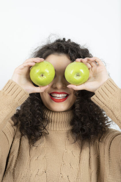 食物一个卷曲的女人 手里拿着一个红色的唇膏 手里拿着绿色的苹果食物 女人 绿色 水果 苹果 有机 营养 情感 美丽 美味 可口 休闲 营养 营养 成熟