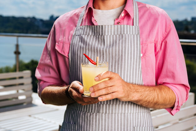 快餐为客人准备鸡尾酒专业经验丰富的服务员穿着粉色衬衫为客人准备鸡尾酒用餐食物自然