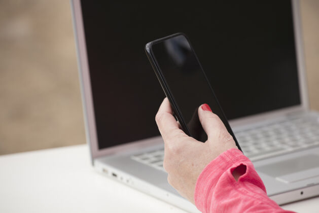 屏幕女人手里拿着电话 户外工作台上有电脑女人数字游牧科技