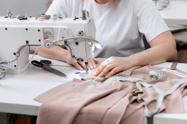 工作女人在缝纫机后面缝纫线生产制造