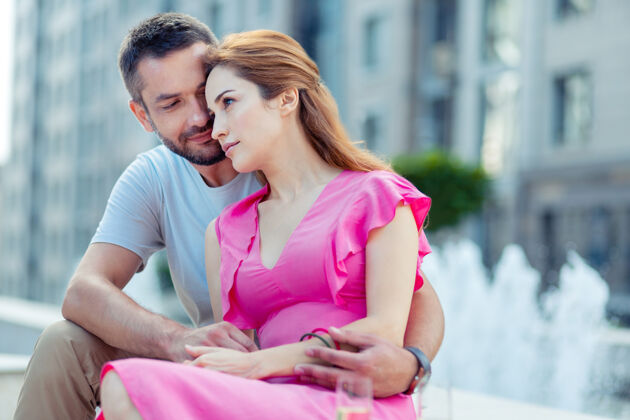 约会强烈的感情愉快的已婚夫妇坐在喷泉边拥抱对方夫妻沟通爱情