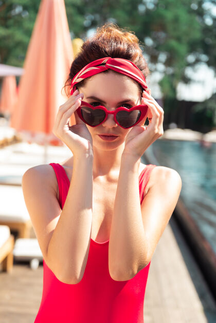 高兴夏日的心情站在游泳池旁边的好姑娘摘下了太阳镜人性感苗条