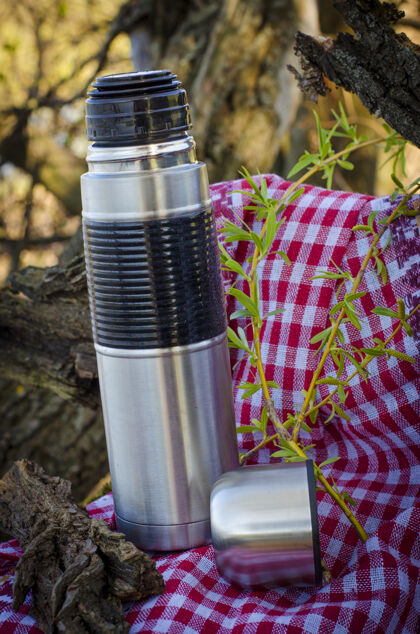 杯子热水瓶和一个杯子在大自然中使用旅游安全运动