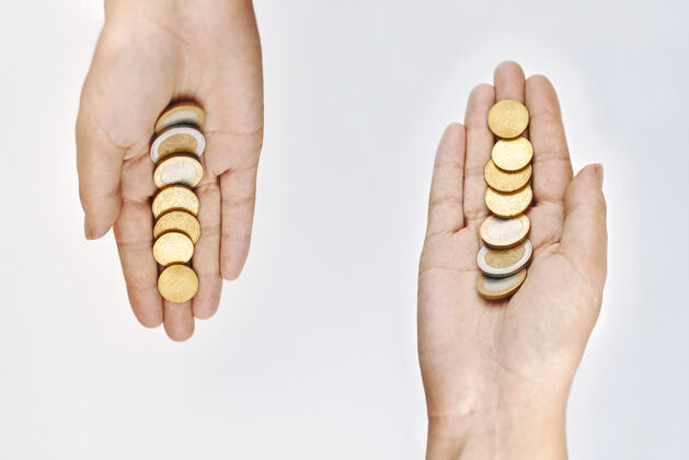 昂贵两只手拿硬币富有经济堆