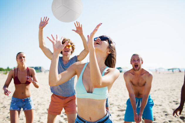 自由一群朋友在沙滩上玩排球海洋无忧无虑海滨