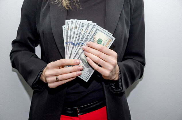 富人一个手里拿着美元的女商人的特写镜头手薪水货币