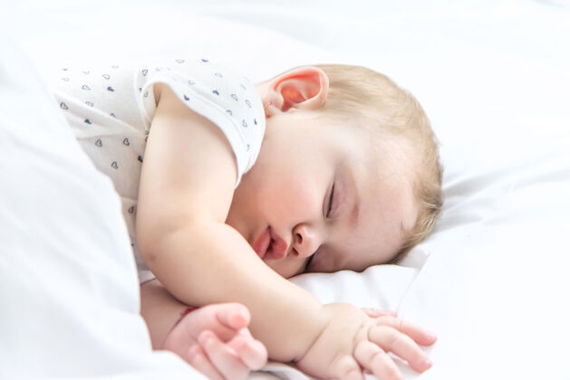 可爱宝宝睡在白色的床上小休息梦