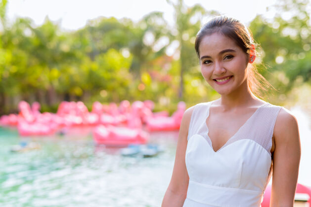 船年轻美丽的亚洲女游客在湖边户外放松的画像快乐东南马尾辫