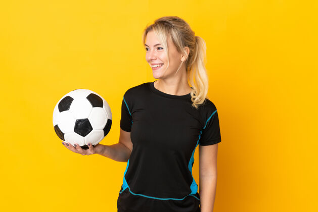 人年轻的俄罗斯足球运动员女子孤立在黄色背景看一边成人年轻肖像