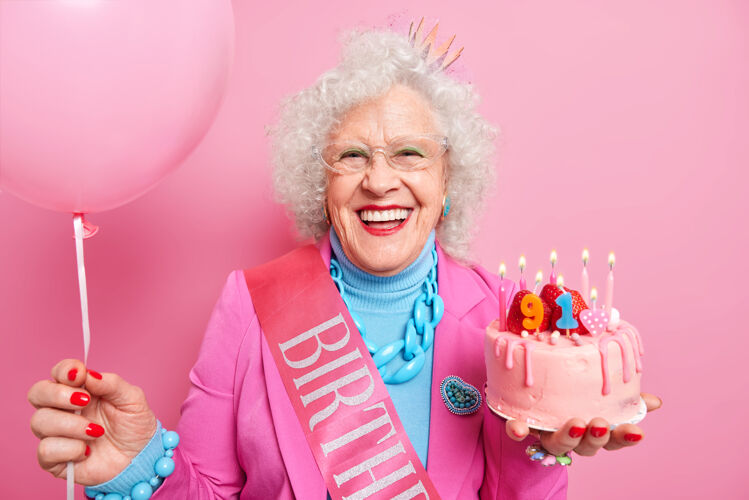 祖母特别的场合年龄和节日概念快乐的微笑皱纹老妇人举行节日草莓蛋糕充气气球准备党或生日庆祝表达良好的情绪蛋糕享受满意