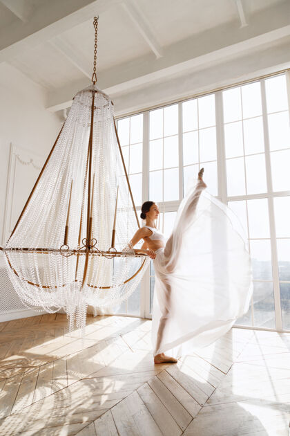 窗户穿着白色裙子的优雅舞者靠近窗户优雅女性舞蹈