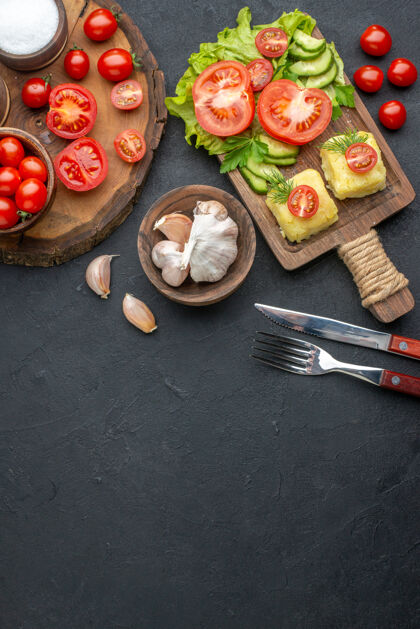 菜肴上图：整个切好的新鲜蔬菜和香料放在木板上 白色毛巾餐具放在黑色的奶酪表面勺子新鲜蔬菜毛巾