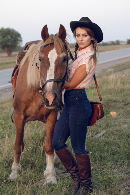 夫妇穿牛仔黑帽衬衫牛仔裤配马的女孩牧场放牧女人