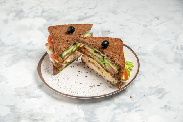 盘子美味三明治的正面图 黑色面包上装饰着橄榄色 盘子上有白色的污渍美食食物青蛙