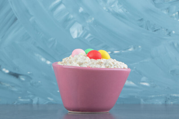 早餐一盘粉红色的燕麦片粥 里面有五颜六色的糖果素食者健康的食物素食者