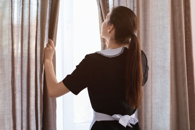 清洁女管家打开房间窗户上的窗帘早晨女佣成人