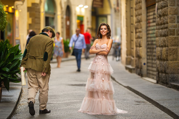 时尚新娘一个穿着粉色婚纱的新娘走在意大利佛罗伦萨年轻模特微笑城市