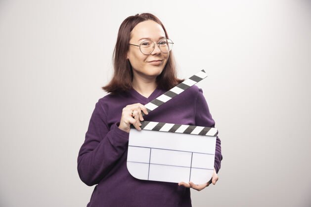 磁带一个年轻的女人在一张白色的照片上摆着一个电影院的带子高质量的照片女人人类镜头