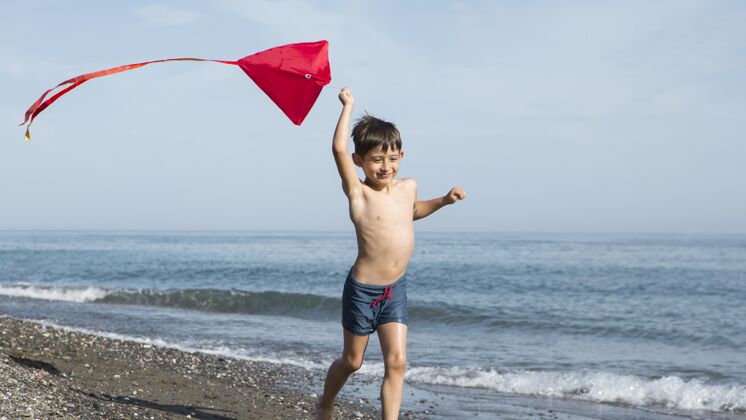 放松全镜头的孩子在沙滩上奔跑户外夏天假期