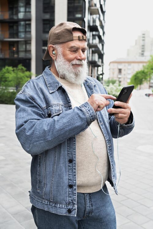设备在城市里 带着智能手机的老人在户外城市垂直老年人