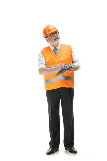设备一个穿着建筑背心和橙色头盔的建筑工人站在白色的工作室背景上安全专家 工程师 工业 建筑 经理 职业 商人 工作理念成人工作男性