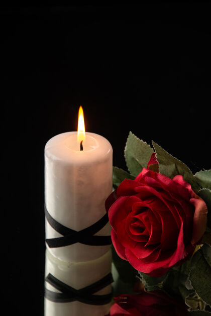 光在黑色上用红花点燃蜡烛的正视图放松庆典打蜡