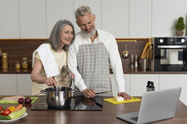 书房老两口在厨房用笔记本电脑上烹饪课女性老人房子