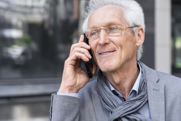 老年人城里的一个老男人在用智能手机聊天老年人城市老年