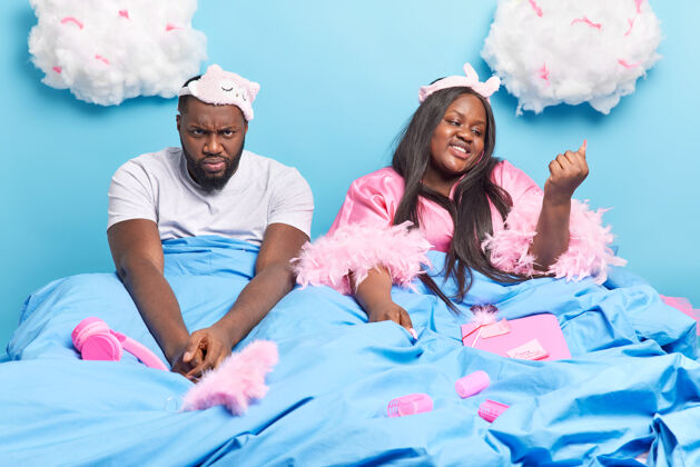 女性一对非洲裔美国夫妇在舒适的床上 在毯子下合影 准备在蓝色的隔离地上睡觉欢呼帅哥忧郁