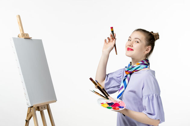 人物前视图女画家在白墙上画画画家画架铅笔艺术画女人专业铅笔肖像