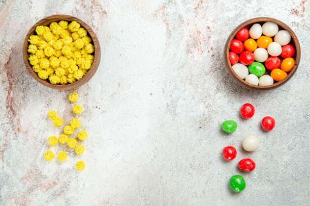 视图顶视图不同颜色的糖果放在白色的桌子上彩色糖果糖玉米胡椒健康