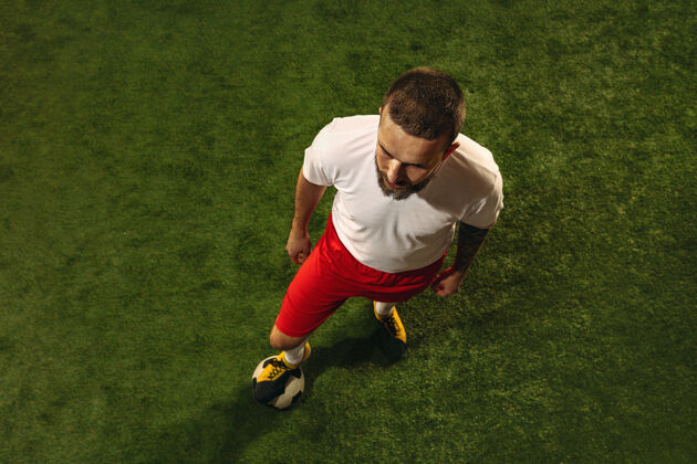 鞋白种人足球或足球运动员在草地上的绿色背景俯视图年轻男性运动模型训练 练习 踢球 进攻 接球运动概念 比赛 胜利运动活动球员