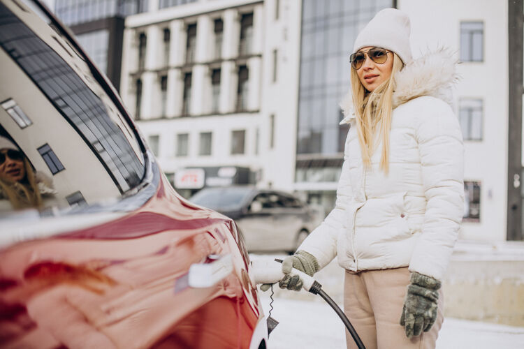 环保女人充电红色电动车 在冬天的时候工作停车汽车