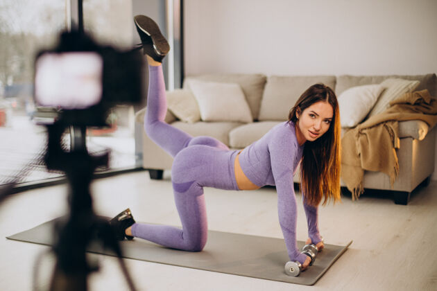 人女人在家里锻炼和制作视频运动房间训练