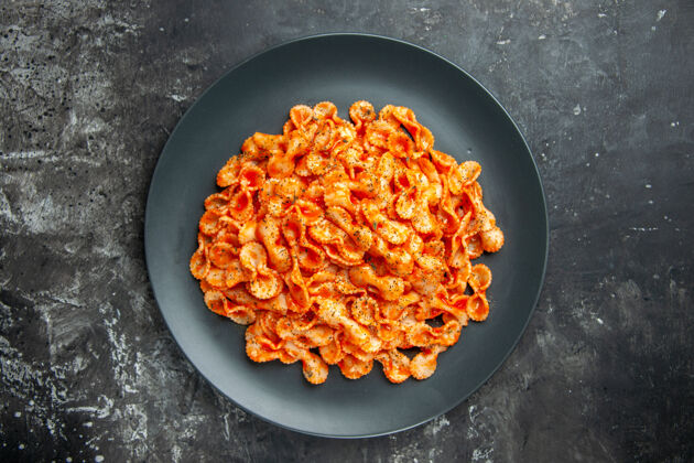食物上图：在黑暗的背景下 在一个黑色的盘子里 可以看到美味的意大利面胡萝卜美味烹饪