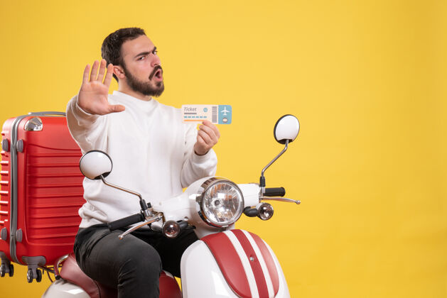 运动员旅游概念与年轻的情感男子坐在摩托车上 手提箱上显示黄色车票运动训练运动员