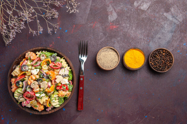 菜肴俯瞰美味的蔬菜沙拉与调味品在黑暗的背景健康饮食沙拉蔬菜午餐食物午餐蔬菜
