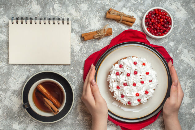 酸橙上图：手拿美味的奶油蛋糕 用红色毛巾装饰着水果水果杯子醋栗
