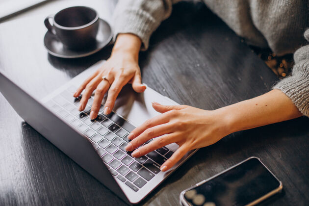 学习女性的手在电脑键盘上打字通信咖啡封闭