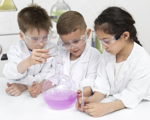 女孩好奇的孩子在学校做化学实验男孩学习实验室