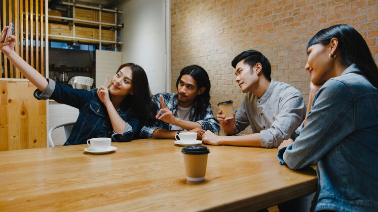 自拍一群快乐的亚洲年轻人在咖啡馆和她的朋友一起自拍 玩得很开心会议周末朋友