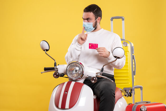 视图旅行概念的俯视图 戴着医用面罩的人坐在摩托车上黄色手提箱球员