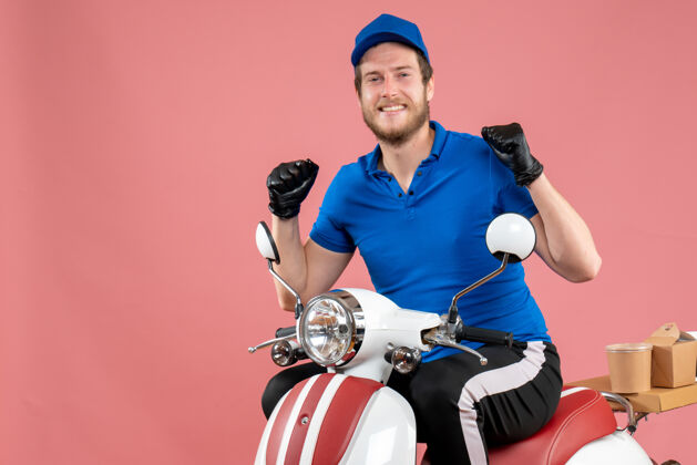 车头正面图身穿蓝色制服 戴着手套的男性快递员骑着粉色快餐服务的送餐自行车颜色摩托车头盔