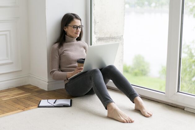 女人坐在地板上操作笔记本电脑的女人科技科技女性