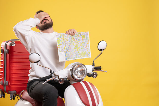 旅行旅行概念与过度疲劳的家伙坐在摩托车上 手提箱上的黄色男性人黄色