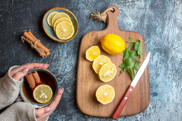 新鲜上图：新鲜柠檬和薄荷刀放在木制砧板上木材肉桂削减