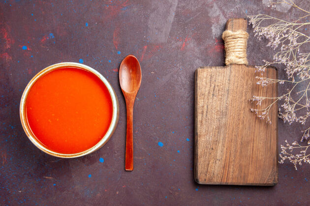 制作俯瞰美味的西红柿汤 用新鲜的西红柿在黑暗的桌子上烹制而成的酱汁西红柿汤油漆刷子西红柿