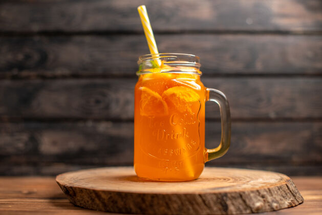 水果在棕色背景上 木制托盘上的玻璃管中的新鲜橙汁俯视图冰木材管