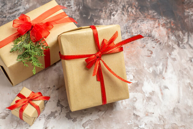 盒子前视图可爱的圣诞礼物与红色蝴蝶结绑在灯光背景圣诞节新的包装