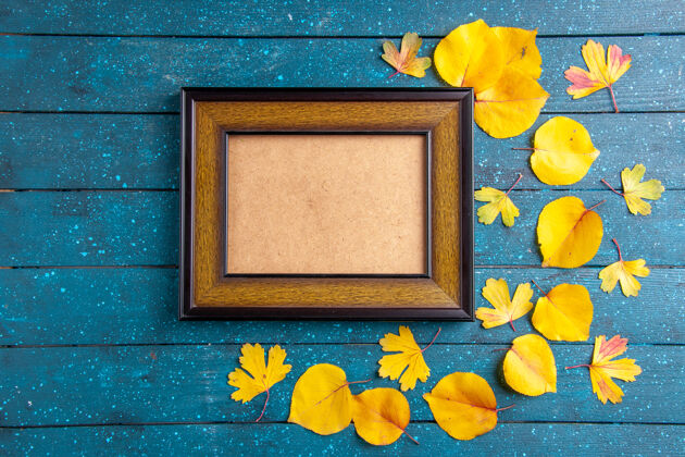 背景顶视图内空木制相框和黄色树叶在不同大小的蓝色背景上大小内部空白